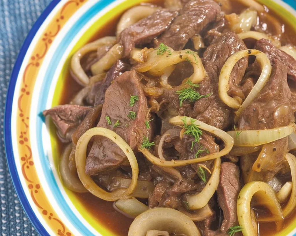 Delicious Filipino Bistek Tagalog beef steak served with onions and a tangy sauce.