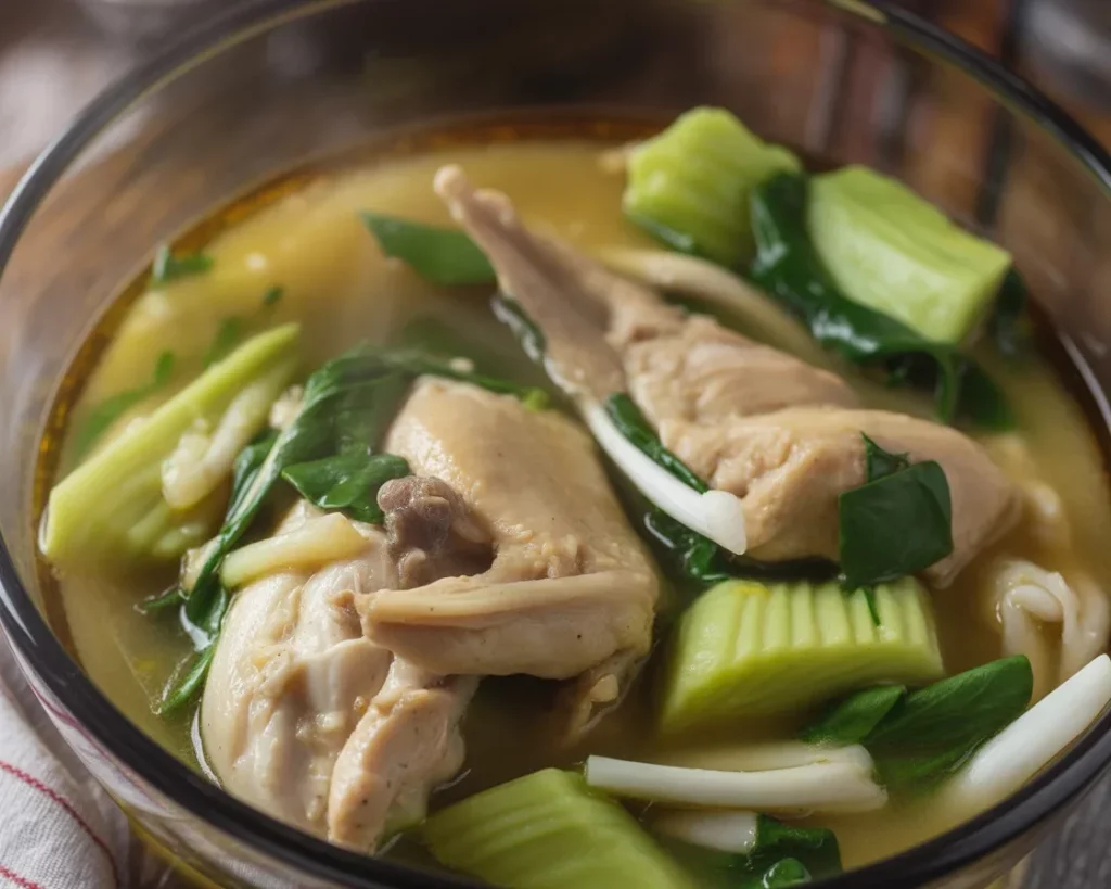 Bowl of Filipino chicken binakol soup with coconut, chicken, and fresh vegetables.