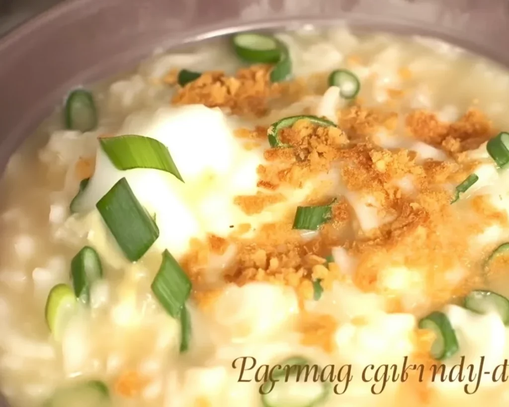 Bowl of Filipino goto, a rice porridge with beef tripe and ginger, garnished with toasted garlic.