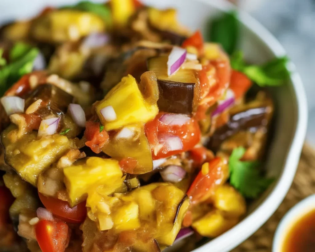 Filipino ensaladang talong, a roasted eggplant salad with tomatoes and onions.