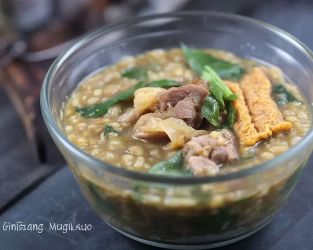 A bowl of ginisang munggo with malunggay featuring mung beans, pork, and spices.