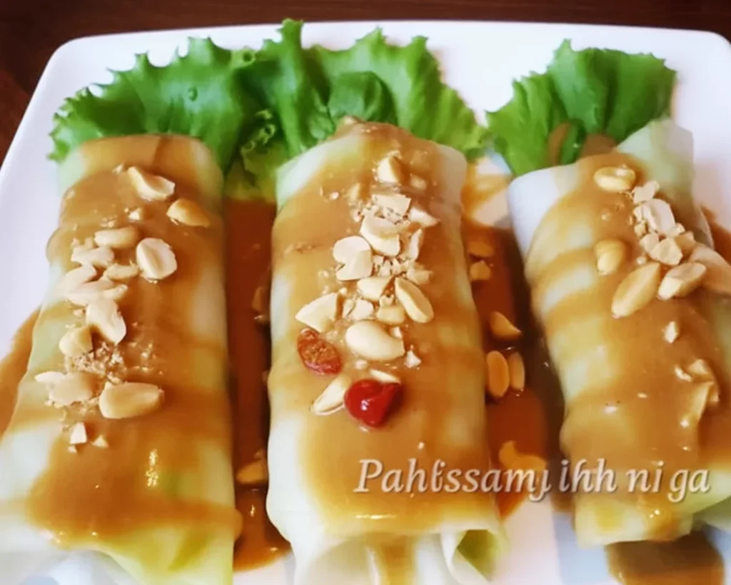 Delicious Filipino lumpiang sariwa filled with vegetables and topped with sweet peanut sauce.