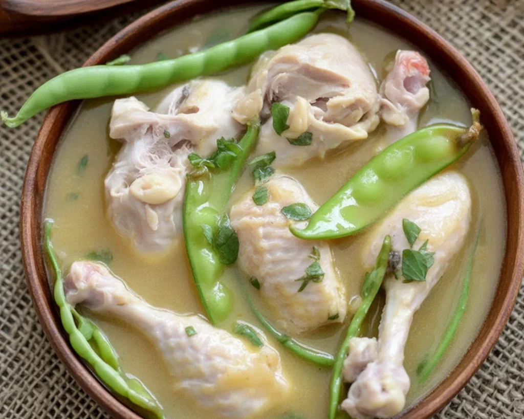A bowl of Filipino sinampalukang manok, chicken in tamarind soup garnished with vegetables.
