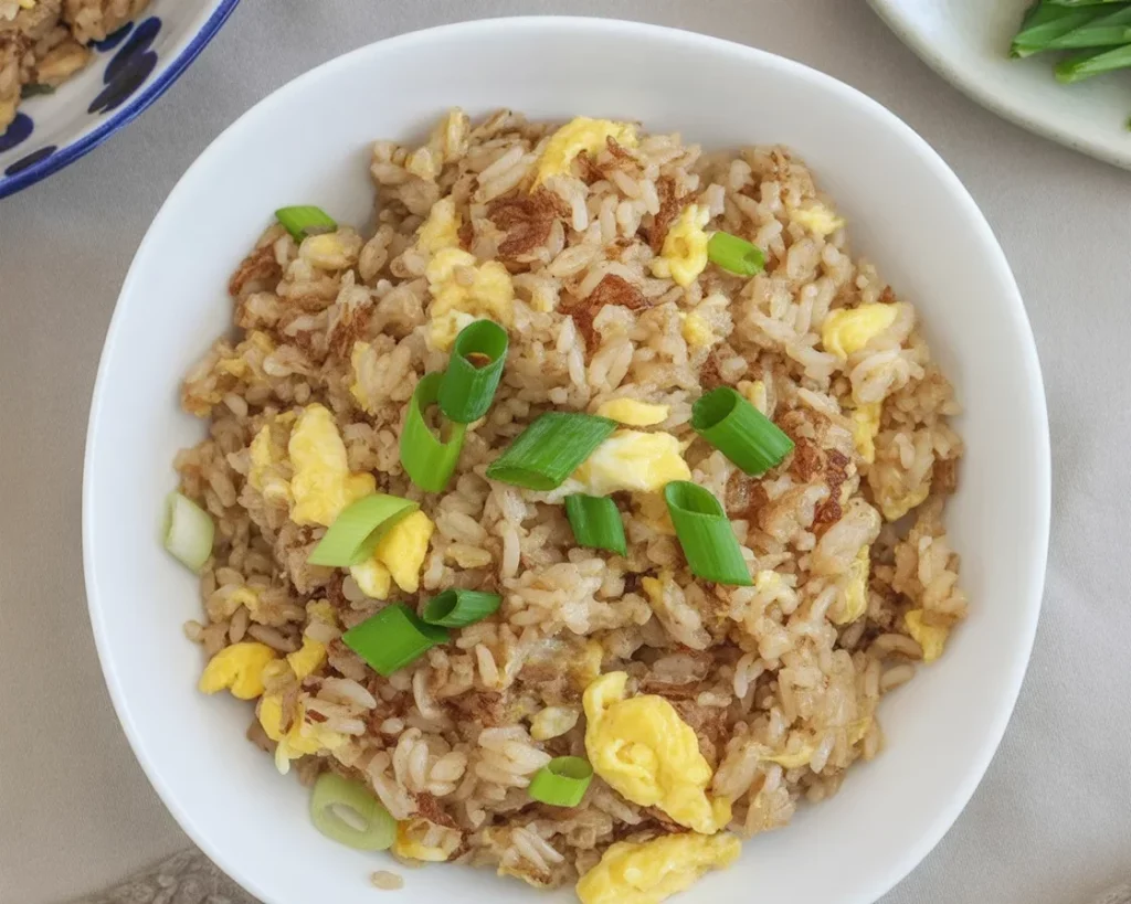 Filipino tinapa fried rice with smoked fish flakes and green onions in a bowl