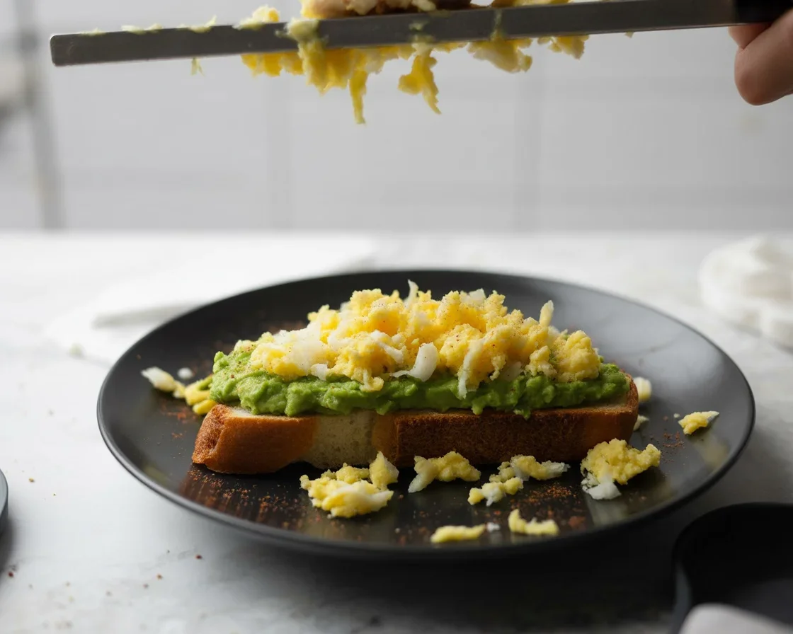Filipino Avocado Toast topped with a fried egg on crusty sourdough bread.