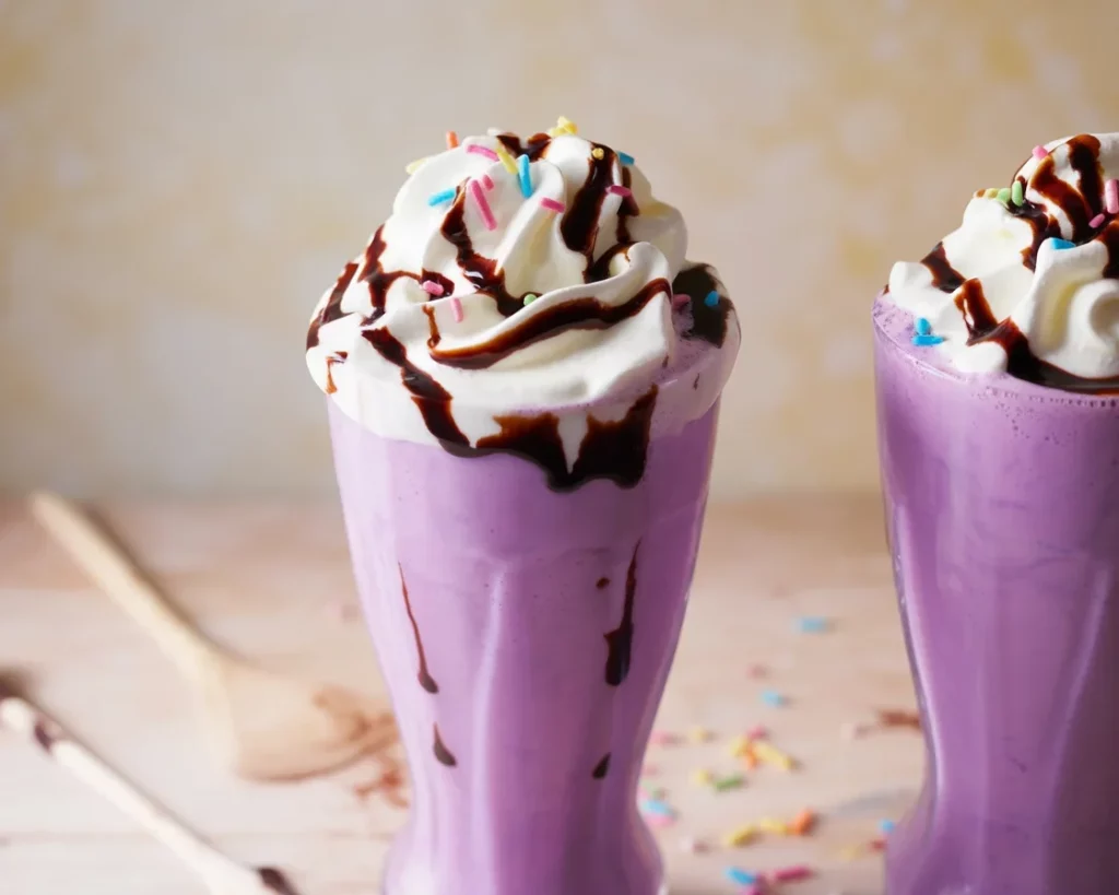 Delicious ube smoothie with purple yam, coconut milk, and ice, served in a glass.