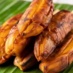 Delicious banana cue, a Filipino street food of fried caramelized saba bananas on a stick.