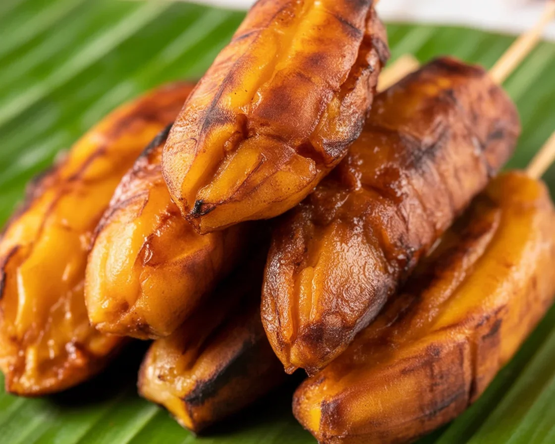 Delicious banana cue, a Filipino street food of fried caramelized saba bananas on a stick.