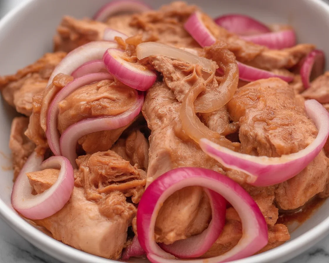 Delicious Chicken Bistek Tagalog served with steamed rice and garnished with onions.
