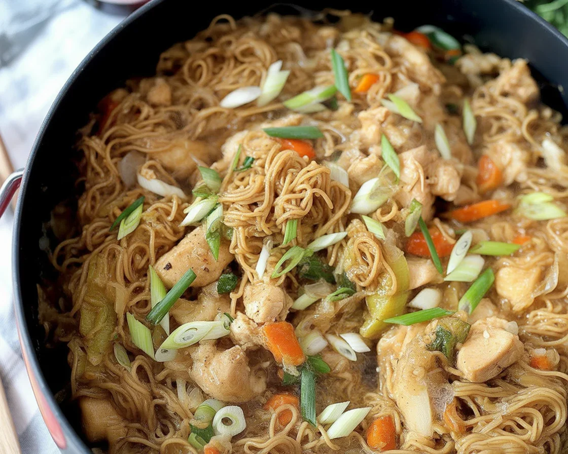 Plate of easy Filipino pancit bihon with vegetables and chicken garnished