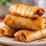 Healthy baked banana turon rolls served with a drizzle of caramel sauce.