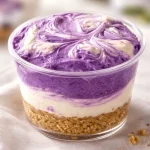 Delicious no-bake ube cheesecake cups garnished with whipped cream and ube jam.