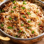 Bowl of Simple Chicken Adobo Flakes Rice topped with a fried egg and green onions.