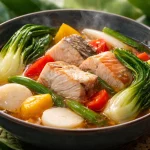 A bowl of simple fish sinigang with fresh vegetables and herbs, perfect for weeknight dinners.