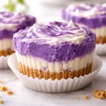 Mini Ube Cheesecake Cups topped with purple ube sauce and colorful sprinkles