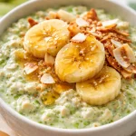 Creamy coconut pandan overnight oats topped with fresh fruit and chia seeds.